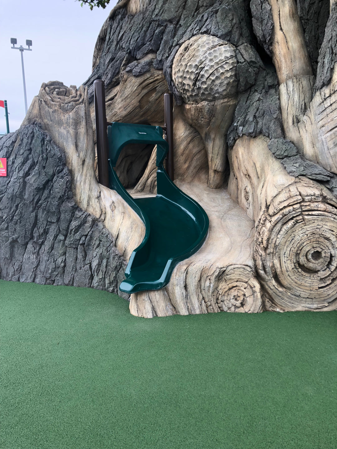 a slide into the side of a mural at a gold course