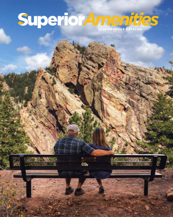 husband and wife sitting on a bench looking at a rocky mountain