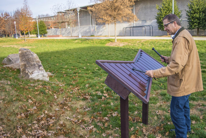 a man playing on a xylophone at the park 