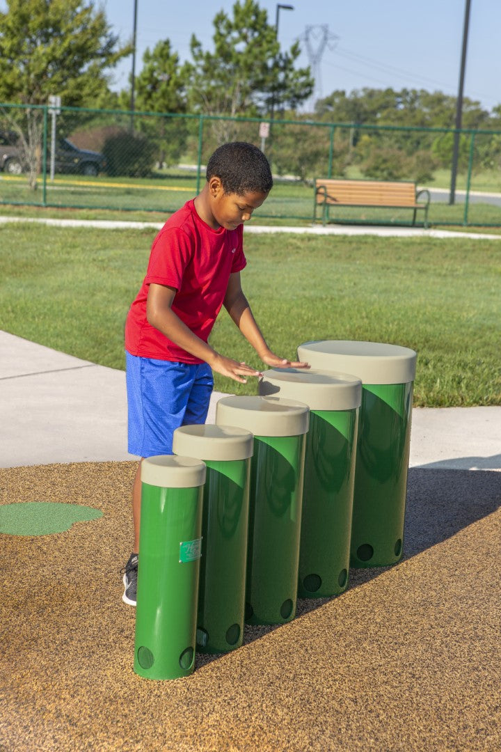 Young boy playing drums at a park