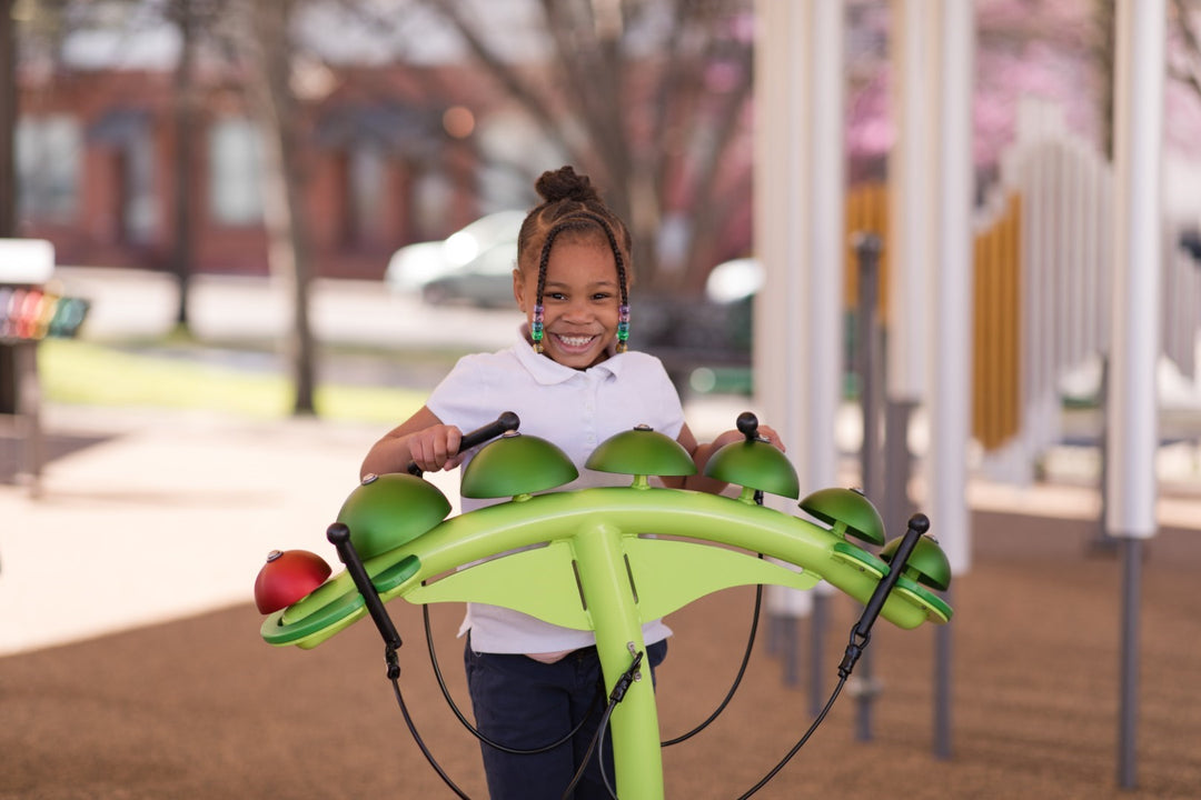 Young girl playing with Caterpillar Bells in a park