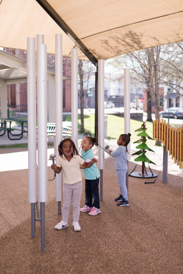 three little girls playing iwth Contrabass Chimes in a park