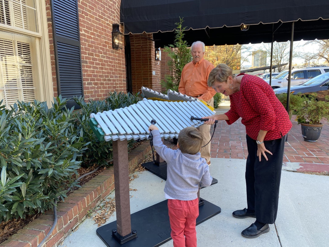 grandparents and grandchild playing the pegasus instrument