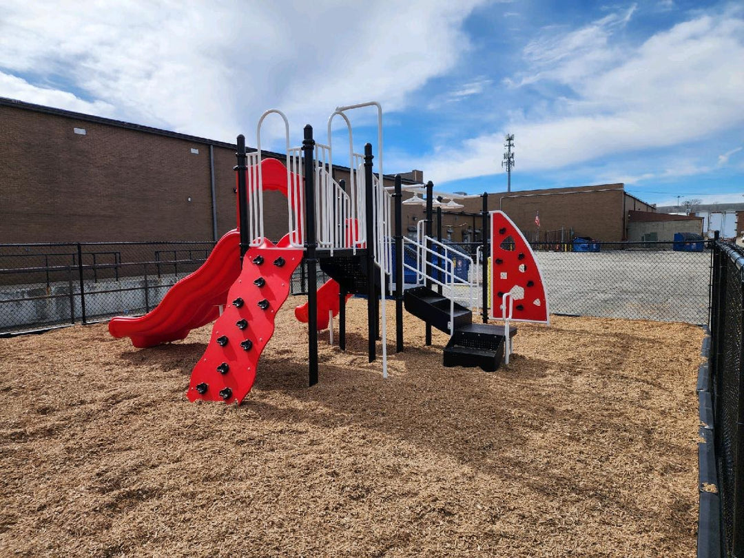 red playground in a bark fenced area